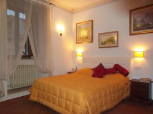 アッシジにあるVia San Rufino 10 Apartmentのベッドルーム(赤い枕の大きな黄色のベッド付)