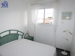 um quarto branco com uma cama e uma janela em Maison Valras-Plage, 3 pièces, 6 personnes - FR-1-781-22 em Valras-Plage