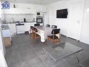 uma cozinha com uma mesa e cadeiras numa cozinha em Maison Valras-Plage, 3 pièces, 6 personnes - FR-1-781-22 em Valras-Plage