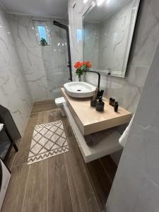 uma casa de banho com um lavatório e um espelho em Karydakis Properties em Zakynthos