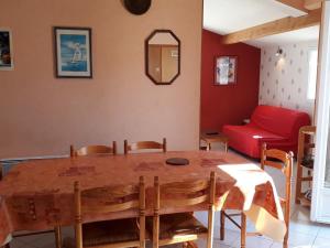 a living room with a wooden table and a red couch at **Maison récente, proche plage, commerces et plan d'eau - L'Aiguillon-sur-Mer** - FR-1-194-275 in LʼAiguillon-sur-Mer