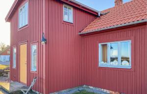 3 Bedroom Stunning Home In Degerhamn في Degerhamn: منزل احمر بسقف احمر