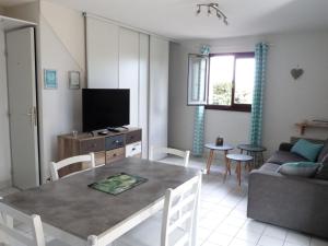 ein Wohnzimmer mit einem Tisch und einem TV in der Unterkunft Maison La Tranche-sur-Mer, 3 pièces, 4 personnes - FR-1-194-279 in La Tranche-sur-Mer