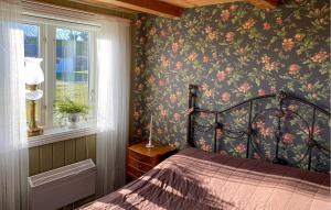 3 Bedroom Stunning Home In Degerhamn في Degerhamn: غرفة نوم مع سرير وورق جدران زجاجي ونافذة