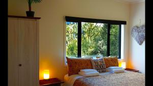 a bedroom with a bed and a large window at Paihia Lighthouse in Paihia