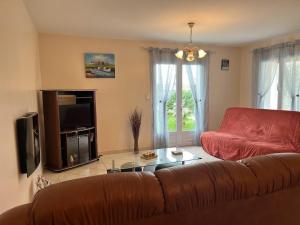 ein Wohnzimmer mit einem braunen Sofa und einem TV in der Unterkunft Maison L'Aiguillon-sur-Mer, 3 pièces, 6 personnes - FR-1-194-277 in LʼAiguillon-sur-Mer