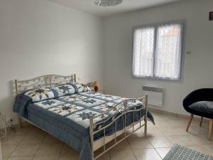 Schlafzimmer mit einem Bett mit blauer Decke in der Unterkunft Maison L'Aiguillon-sur-Mer, 3 pièces, 6 personnes - FR-1-194-277 in LʼAiguillon-sur-Mer