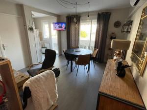 a living room with a table and a dining room at Charmant F2 avec terrasse de 25m² et parking, proche Thermes à Balaruc-les-Bains - FR-1-680-42 in Balaruc-les-Bains