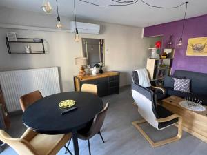 a living room with a table and a couch at Charmant F2 avec terrasse de 25m² et parking, proche Thermes à Balaruc-les-Bains - FR-1-680-42 in Balaruc-les-Bains