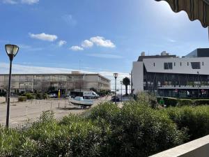 a parking lot with a boat in front of a building at Charmant F2 avec terrasse de 25m² et parking, proche Thermes à Balaruc-les-Bains - FR-1-680-42 in Balaruc-les-Bains