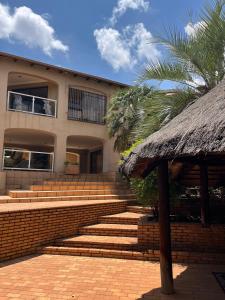 a building with stairs and a straw roof at Spacious peaceful 5 bedroom house in Pretoria