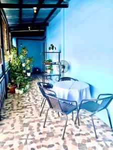 een tafel en stoelen in een kamer met planten bij Patterville Transient House #4 in Iba