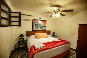 um quarto com uma cama e uma ventoinha de tecto em Villa Serena Centro Historico em Mazatlán