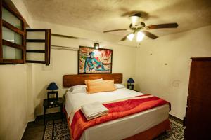 a bedroom with a bed and a ceiling fan at Villa Serena Centro Historico in Mazatlán