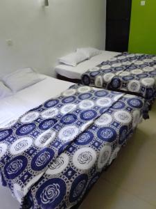 two beds with blue and white covers in a room at Hotel Sea side in Calangute