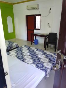 a bedroom with a bed and a table and a desk at Hotel Sea side in Calangute