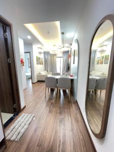 a living room with a table and chairs and a mirror at Mami House - Luxcity Cẩm Phả Serviced Apartments in Cẩm Phả
