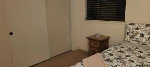 a bedroom with a bed and a table with a window at Be our Guest - Shared Home Lancaster in Palmdale
