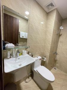 a bathroom with a white toilet and a sink at Mami House - Luxcity Cẩm Phả Serviced Apartments in Cẩm Phả