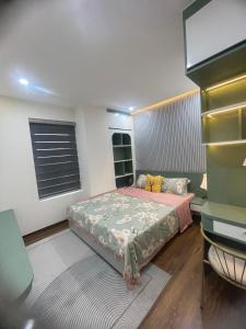 a small bedroom with a bed and a desk at Mami House - Luxcity Cẩm Phả Serviced Apartments in Cẩm Phả
