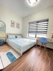 a bedroom with a bed and a desk and a window at Mami House - Luxcity Cẩm Phả Serviced Apartments in Cẩm Phả