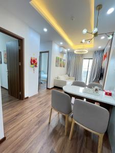a dining room and living room with a table and chairs at Mami House - Luxcity Cẩm Phả Serviced Apartments in Cẩm Phả