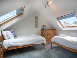 1 dormitorio en el ático con 2 camas y ventana en Hill View en Sidmouth