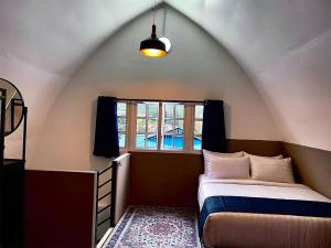 a small bedroom with a bed and a window at Blue Cabins By Pfordten Cottage in Cameron Highlands