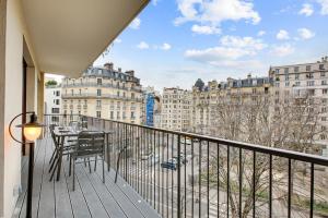 d'un balcon avec une table et une vue sur les bâtiments. dans l'établissement 185 Suite Five - Superb apartment in Paris, à Paris