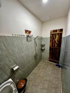 a bathroom with a shower with a sink and a door at Người Măng Đen Homestay in Kon Von Kla