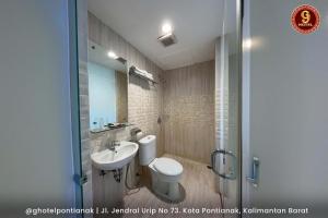 G-Hotel Pontianak في بونتياناك: حمام مع مرحاض ومغسلة ودش