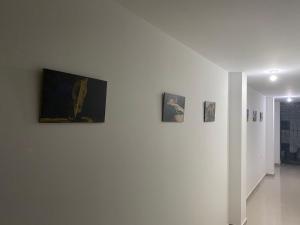 巴耶杜帕爾的住宿－HOTEL IBIZA，白色墙上有三张照片的房间
