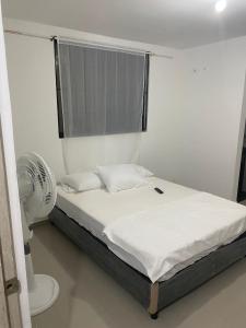 a bedroom with a bed with a fan and a window at HOTEL IBIZA in Valledupar