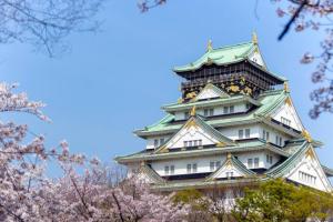 a japanese castle withakura trees in front of it at NEW【駅から2分】USJ空庭難波梅田まで10分!まるごと一軒家貸し切り!大人数宿泊可能!駐車場有 in Osaka