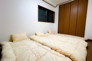 two beds in a room with a large bed at NEW【駅から2分】USJ空庭難波梅田まで10分!まるごと一軒家貸し切り!大人数宿泊可能!駐車場有 in Osaka