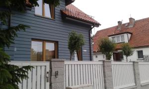 a blue house with a white fence at Dom Wakacyjny Solano in Ustka
