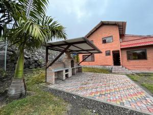 ein Backsteinhaus mit einer Steinterrasse neben einer Palme in der Unterkunft Estancia Esperanza Quinta Vacacional 