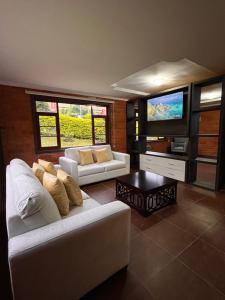 ein Wohnzimmer mit 2 Sofas und einem Flachbild-TV in der Unterkunft Estancia Esperanza Quinta Vacacional 