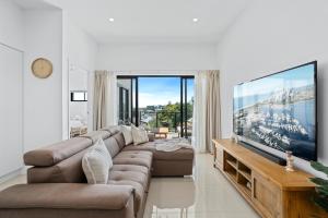 a living room with a large flat screen tv at Spice Broadbeach - GCLR in Gold Coast