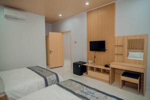 a hotel room with two beds and a television at BLUE OCEAN VILLA in Cu Lao Thu