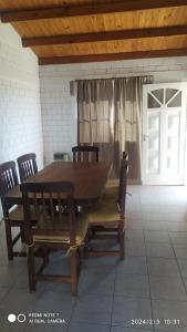 a wooden table and chairs in a room with a door at El nogal in Saladillo