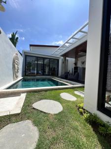 a swimming pool in the backyard of a house at Bali Bird Villa Canggu in Dalung