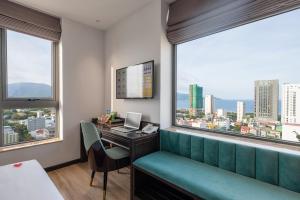 a room with a desk and a computer and a window at Cordial Hotel and Spa in Da Nang