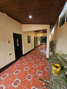 a hallway with a red tile floor in a building at Hostal Sanjuanerita in San Juan La Laguna