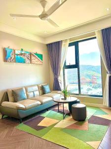 a living room with a couch and a large window at ALTARA Quy Nhơn - RUBY Luxury Apartment in Quy Nhon