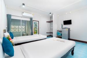 a hotel room with two beds and a tv at The Palm Krabi Residence And Resort in Ban Khlong Chi Lat