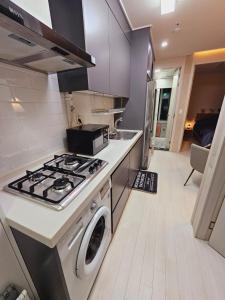 a kitchen with a stove and a washing machine at 서울의 야경이 멋진 옐로우 하우스 in Seoul