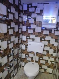 a bathroom with a toilet and a wall covered in envelopes at Kishori ram guest house 5 minute walking distance from railway station in Ayodhya