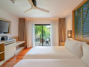 a hotel room with a large bed and a television at Amari Koh Samui in Chaweng