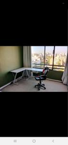 a desk and a chair in a room with a window at Habitaciones en las condes, Cercano a metro in Santiago